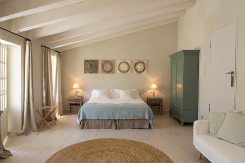 a bedroom with a bed and a couch at Jardí de Ses Bruixes Boutique Hotel in Mahón