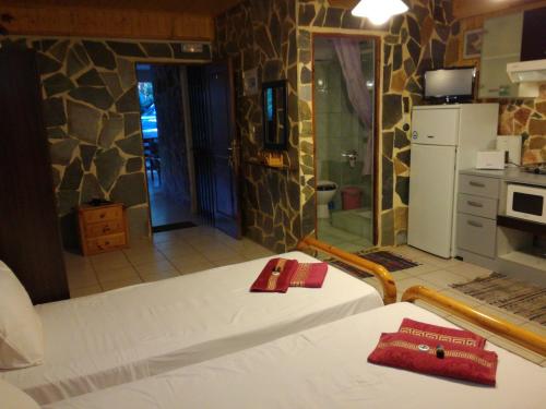 a room with a bed and a bathroom with a kitchen at Apartments Zoumperi in Nea Makri