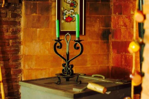 un porte-bougie avec deux bougies vertes sur une table dans l'établissement Casa Rural Entre Volcanes de Almagro, à Almagro
