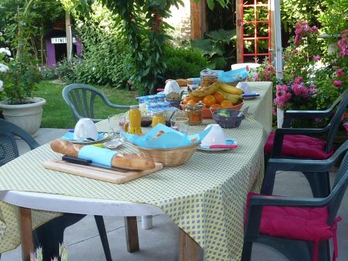 - une table avec petit-déjeuner composé de pain et de fruits dans l'établissement Le patio d'Eric B&B, à Aubigny-au-Bac