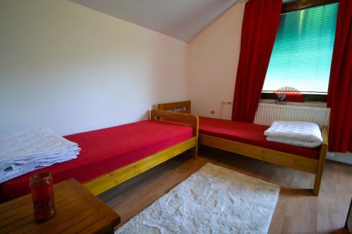 a bedroom with a bed and a window with red curtains at VIP Rooms Foča, Accommodation Foca, Foca Rooms in Foča