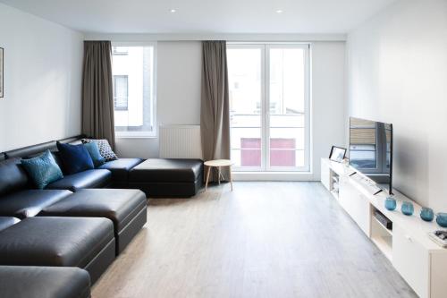 a living room with a couch and a television at Villa Wellington in Ostend