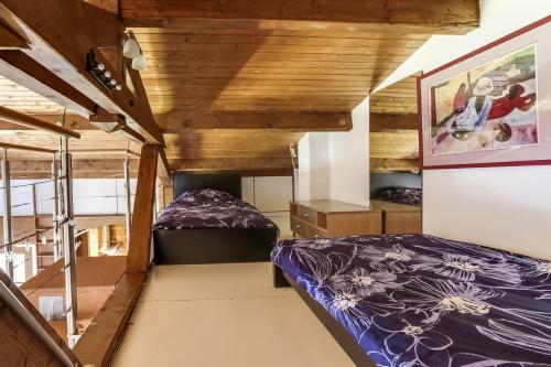 LʼHuezにあるChalet Athena Alpe d' Huezの屋根裏のベッドルーム(ベッド1台、階段付)