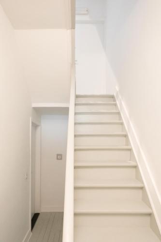 a staircase in a white room with white walls at Villa Wellington in Ostend