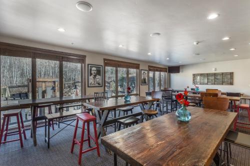 un restaurante con mesas y sillas de madera y ventanas en Silver Baron Lodge, en Park City