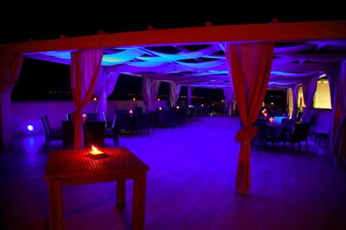 a room with a table and a room with purple lights at BV Airone Resort in Marina di Sibari