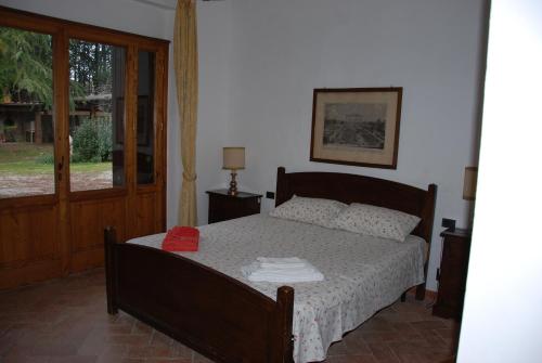 a bedroom with a bed with a red hat on it at Agriturismo San Vettore in Gambassi Terme