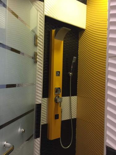 a bathroom with a shower with a yellow door at Luxury Mohandeseen Apartment in Cairo
