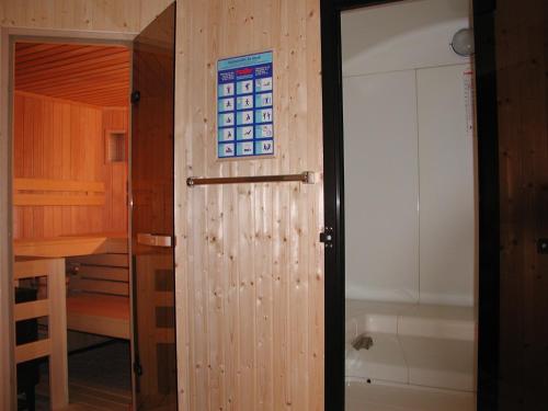 a bathroom with a wooden door and a bath tub at Gasthof Lechner in Rasun di Sopra