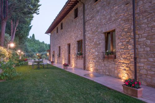 an outdoor patio with a table and a stone building at Antica Fonte in Assisi