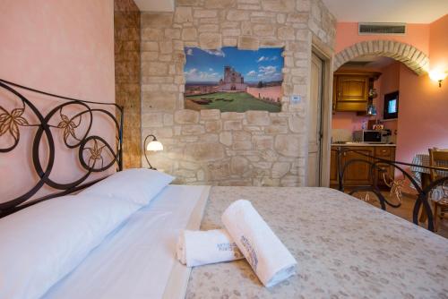 a bedroom with a bed with a stone wall at Antica Fonte in Assisi