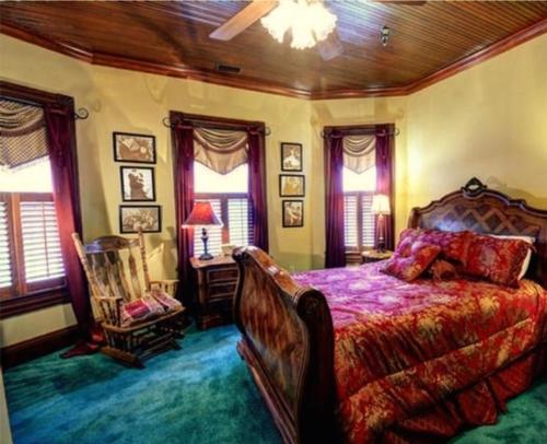 a bedroom with a bed and a chair and windows at Thomasville Bed and Breakfast in Thomasville
