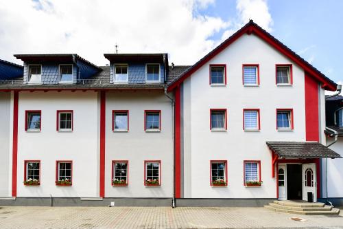 une maison blanche avec des ornements rouges et des fenêtres dans l'établissement Hotel Zum Stern Spreewald, à Werben