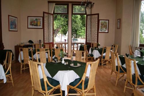 a dining room with tables and chairs and a window at Hotel La Casona del Llano in Oaxaca City