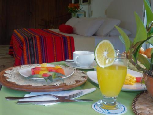 a table with a plate of fruit and a glass of orange juice at Hotel Casa Santa Monica Norte in Cali