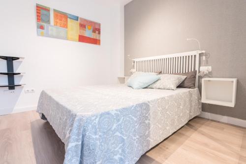 a bedroom with a bed with a blue and white blanket at Apartamento Galicia in Murcia