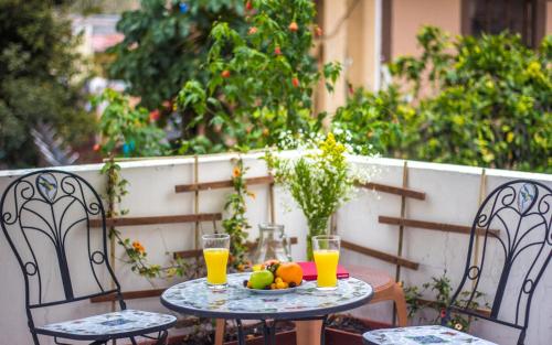 a table with a bowl of fruit and glasses of orange juice at El Patio Hostel Quito in Quito