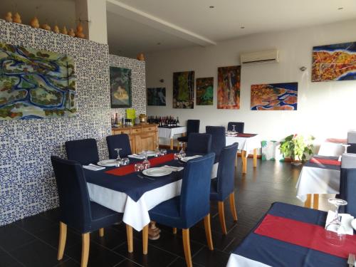 comedor con mesa y sillas azules en Quinta das Delicias, en São Tiaguinho