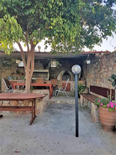 a park with benches and a table and a tree at Nina Apartment in Chania Town