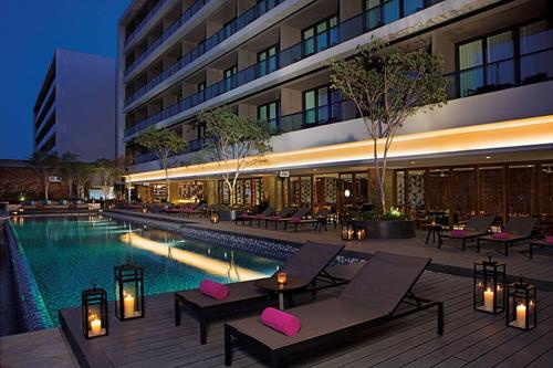 a hotel with a pool and chairs and a building at Breathless Cabo San Lucas - Adults Only in Cabo San Lucas