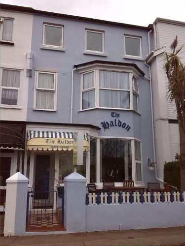 a blue building with a white fence in front of it at The Haldon Guest House in Paignton