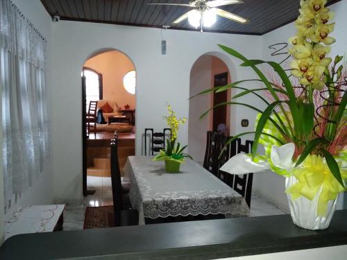 een eetkamer met een tafel met een vaas met bloemen bij Viverdi Hotel in Arujá