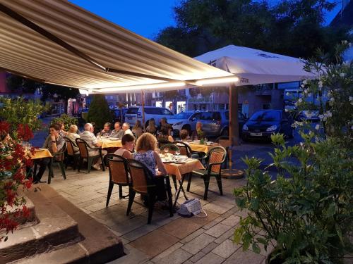 un groupe de personnes assises à des tables dans un patio dans l'établissement La Bonne Franquette, à Villé