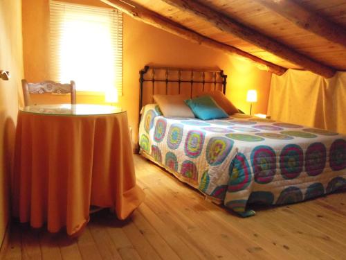 Un dormitorio con una cama con una mesa. en Casa Rural El Riandero, en Linares de la Sierra