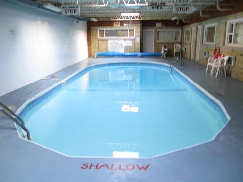 a large swimming pool in a gym with blue illumination at Canadiana Motel in Hanover