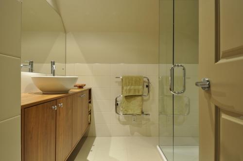 ein Bad mit einem Waschbecken und einer Glasdusche in der Unterkunft Lansdown Villa Apartments in Wanaka