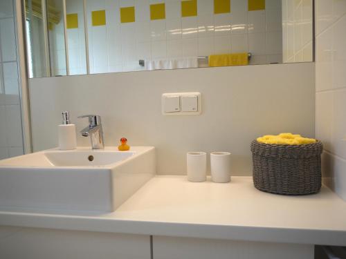 a white bathroom with a sink and a mirror at Lebendiges Linden in Hannover