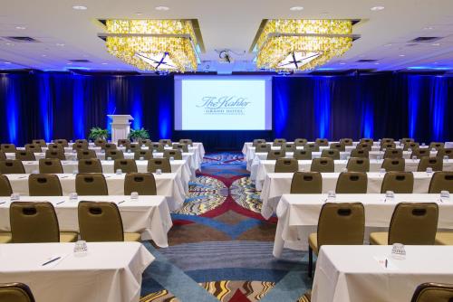 una sala de conferencias con mesas y sillas blancas y una pantalla en Kahler Grand Hotel, en Rochester