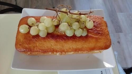 a piece of toast with grapes on a white plate at AL 32 B&B in Massa Marittima