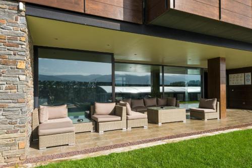 a patio with couches and chairs on a house at Apartaments Turístics Puigcerdà - La Closa in Puigcerdà