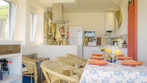 a dining room with a table with chairs and a kitchen at Magoito1 in Sintra