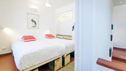 a bedroom with a bed with white sheets and red pillows at Magoito1 in Sintra