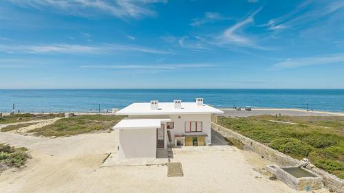 a house on the beach with the ocean in the background at Magoito1 in Sintra