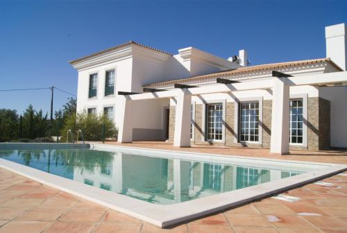 a house with a swimming pool in front of it at Quinta da Esteva in Moncarapacho
