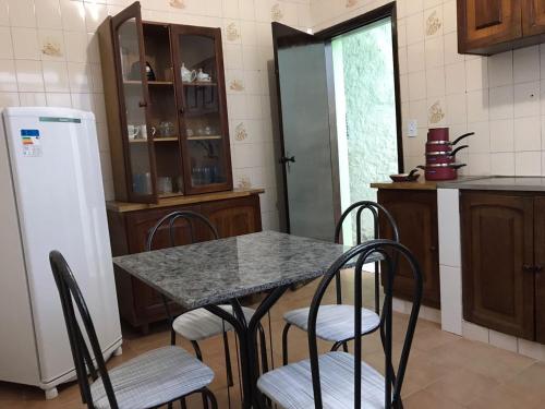La cuisine est équipée d'une table, de chaises et d'un réfrigérateur. dans l'établissement Pousada Coração de Jesus, à Aparecida