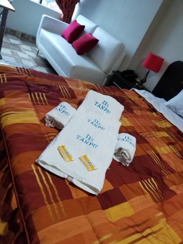 a bed with two white towels and a couch at Imperio Tanpu Q in Lima