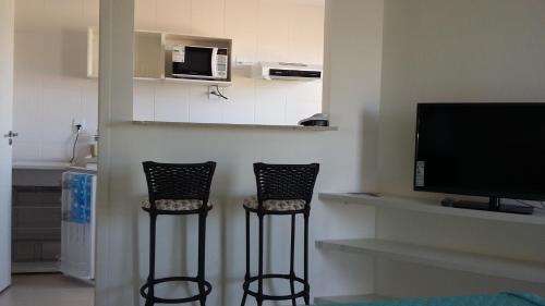 two chairs in a living room with a television at Condado Aldeia dos Reis 205 e 213 in Mangaratiba