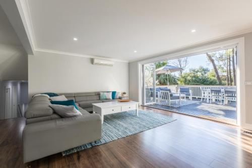 a living room with a couch and a table at QUPI HOUSE formerly Rex's Yarra Valley House in Healesville