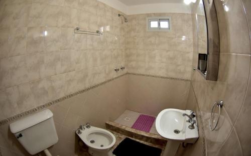 a bathroom with a toilet and a bidet and a sink at El Zuriaco in Santa Rosa de Calamuchita