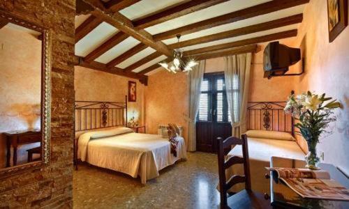 AlfacarにあるHospedería Ruta de Lorcaのベッド2台と鏡が備わる広い客室です。