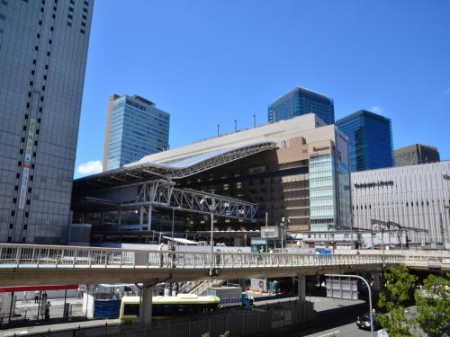 a building with a bridge in a city with tall buildings at Hotel Wing International Select Osaka Umeda in Osaka