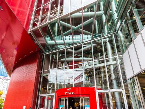 a red bus parked in front of a building at Hotel Wing International Select Osaka Umeda in Osaka