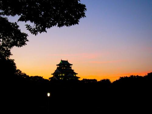 a silhouette of a pagoda at sunset at Hotel Wing International Select Osaka Umeda in Osaka