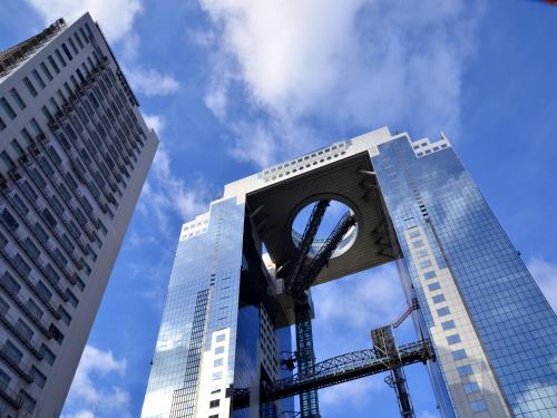 a view of two tall buildings with a sculpture in the middle at Hotel Wing International Select Osaka Umeda in Osaka