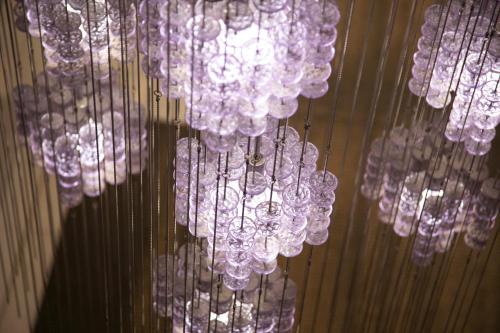 a bunch of glass chandeliers hanging from a wall at Mito Hotel Season in Mito