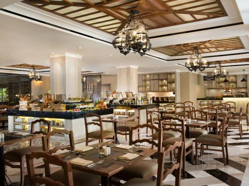 a restaurant with tables and chairs in a room at Melia Purosani Yogyakarta in Yogyakarta